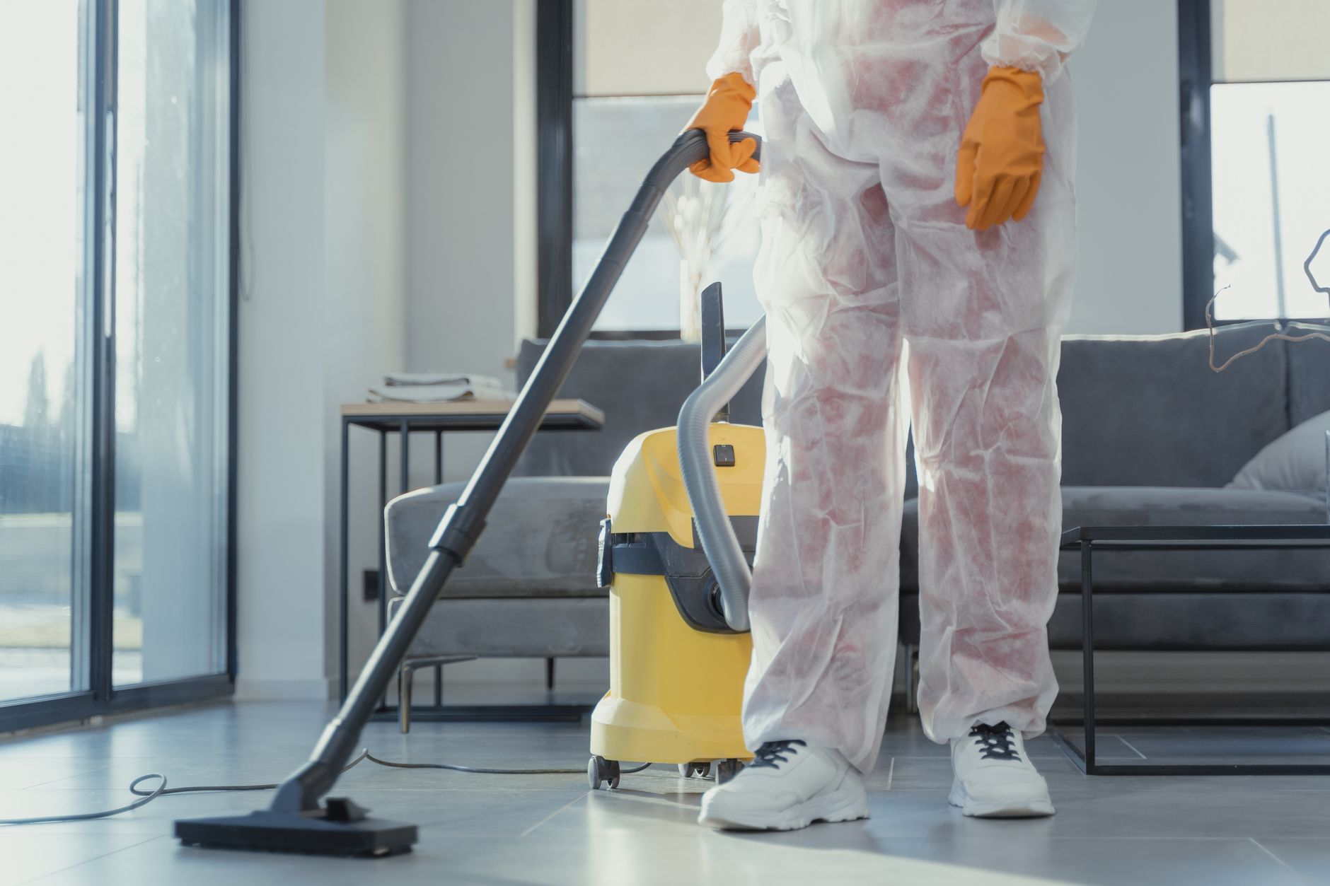 A Star Pro Mold Removal technician in protective gear performing an air quality test inside a Cedar Hill home.